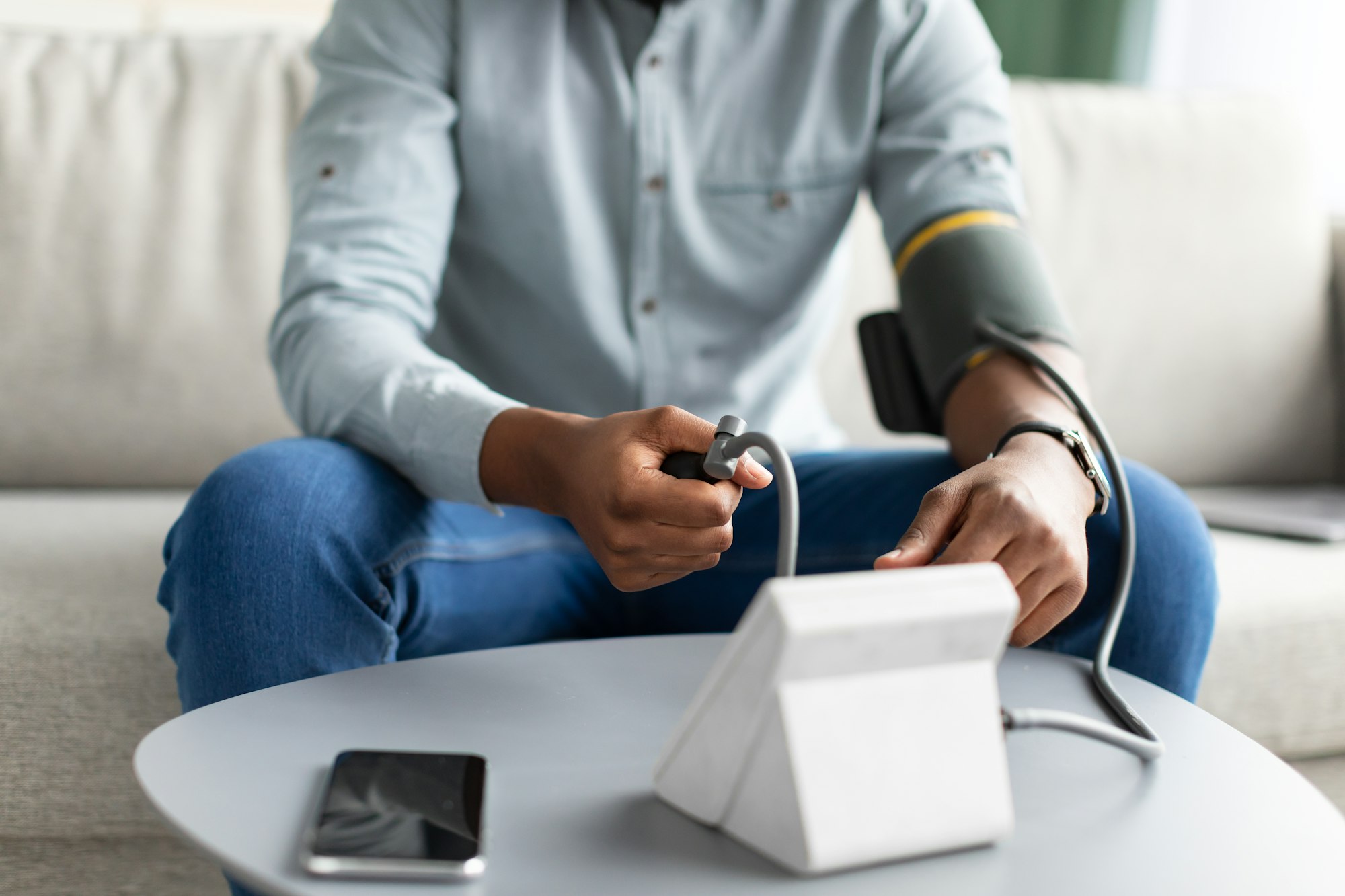 Unrecognizable African Man Measuring Arterial Pressure Having Hypertension At Home